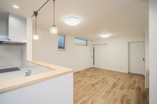 街中の狭小地に建つ店舗併用住宅の2階建てのオウチ